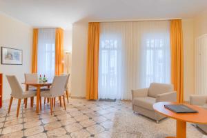 ein Wohnzimmer mit einem Tisch, einem Sofa und Stühlen in der Unterkunft Villa Seestern Whg. 760 in Binz