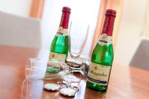 zwei Flaschen Wein und Gläser auf einem Holztisch in der Unterkunft Villa Seestern Whg. 760 in Binz