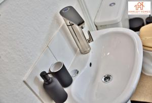 a sink with a faucet and two cups on it at The Highstreet Retreat - Luxurious, Central & Spacious! By Hinkley Homes Short Lets & Serviced Accommodation in Bridgwater +53 photos
