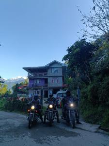 a group of people riding motorcycles down a road at Wind Valley Homestay in Pelling