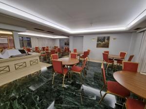 a restaurant with tables and chairs in a room at Savoy Hotel in Piraeus