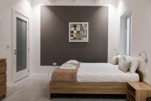 a bedroom with a large bed with a wooden frame at Privilege Suite in Tal-Pietà
