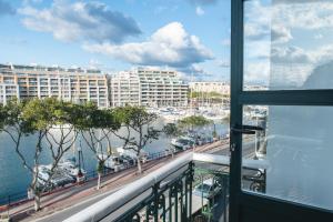 balcone con vista su un porto turistico e sugli edifici di Privilege Suite a Tal-Pietà