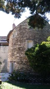 ein großes Backsteingebäude mit einem Fenster und einer Treppe in der Unterkunft La tour du logis, gîte 4 * à 15 min du Futuroscope 