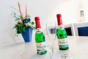 dos botellas de vino sentadas en una mesa con una copa en Haus Margarete Whg_ 2 en Binz