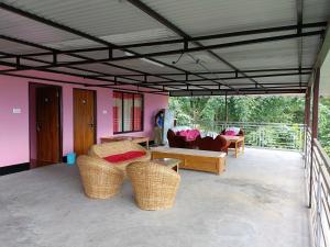 un soggiorno con mobili in vimini e pareti rosa di Wind Valley Homestay a Pelling