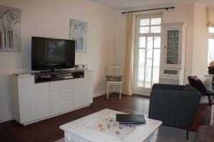 ein Wohnzimmer mit einem TV auf einer weißen Kommode in der Unterkunft Villa Aegir Whg. 4 in Binz