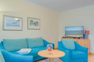 ein Wohnzimmer mit einer blauen Couch und einem Tisch in der Unterkunft Villa Elfeld 2 Whg. 717 in Binz