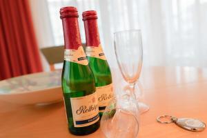 zwei Flaschen Wein auf einem Tisch mit einem Glas in der Unterkunft Villa Elfeld 2 Whg. 717 in Binz