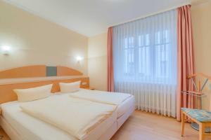 ein Schlafzimmer mit einem Bett und einem großen Fenster in der Unterkunft Villa Elfeld 2 Whg. 717 in Binz + 12 Fotos