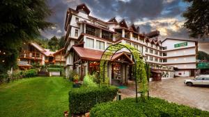 a large building with an arch in front of it at Renest River Country Resort Manali in Manāli
