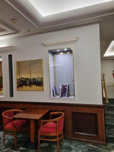 Cette chambre comprend une table, des chaises et un miroir. dans l'établissement Savoy Hotel, au Pirée