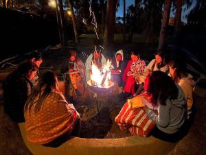 Eine Gruppe von Menschen, die nachts um ein Feuer herum sitzen in der Unterkunft Casa de campo privada cerca a Chan Chan in Trujillo