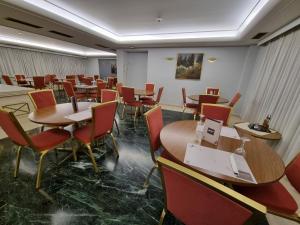 a dining room with tables and chairs in a restaurant at Savoy Hotel in Piraeus