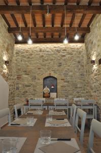 a dining room with a table and chairs and a stone wall at B&B Terra di Marca in Montefortino