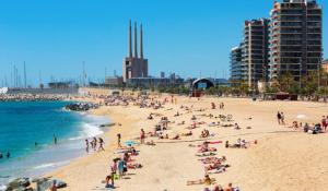 un grupo de personas en una playa cerca del océano en Habitaciones con baño compartido en bonito Apartamento en Badalona en Badalona