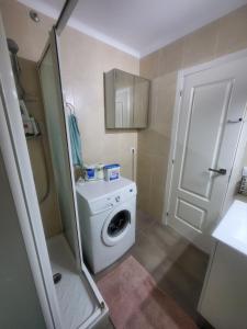 a small bathroom with a washing machine and a washer at Habitaciones con baño compartido en bonito Apartamento en Badalona in Badalona