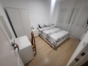 a bedroom with a bed and a table and a mirror at Habitaciones con baño compartido en bonito Apartamento en Badalona in Badalona