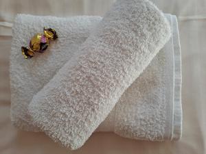 a white towel with two butterflies sitting on it at Plázs Apartman Balatonlelle in Balatonlelle
