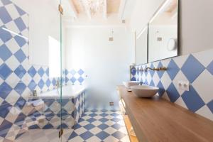a bathroom with two sinks and blue and white tiles at Es Corte Vell - Adults Only in Bunyola