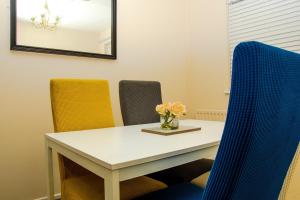 una mesa y sillas con un jarrón de flores. en XB Property - Comfy house perfect for families contractors relocators, en West Bromwich
