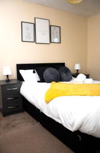 1 dormitorio con 1 cama grande con manta amarilla en XB Property - Comfy house perfect for families contractors relocators, en West Bromwich