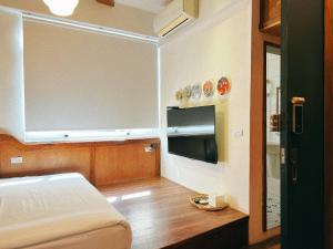a bedroom with a bed and a television in it at Dock Inn in Tainan