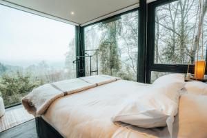 a bedroom with a bed and a large window at Samadhi Eco Resort in Vilcún