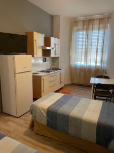 um pequeno quarto com uma cama e uma cozinha em Residence Europa em Piacenza