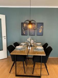uma mesa de jantar com cadeiras e um lustre em Design, Hochschule, Wildpark, Zentral, Waipu TV, Netflix em Pforzheim