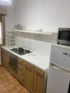a kitchen with a stove and a microwave at Nic holiday house in Santa Marinella