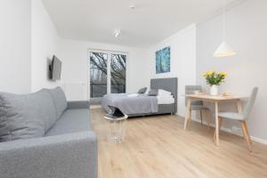 a living room with a couch and a bed at Metro Bielany Apartments with Parking by Renters in Warsaw