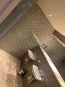 a bathroom with two sinks and a tiled wall at The George Inn in Hatherleigh