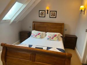 a bedroom with a wooden bed with two night stands at The George Inn in Hatherleigh