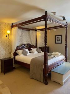 a bedroom with a canopy bed in a room at The George Inn in Hatherleigh
