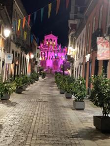 eine leere Straße mit einem rosa Gebäude mit Lichtern in der Unterkunft Viviendas vacacionales San Mateo in Vega de San Mateo