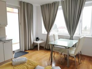 a dining room with a glass table and white chairs at Trnovo apartment with free parking in Ljubljana