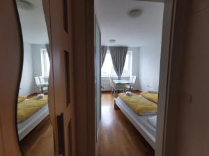 una camera con due letti, un tavolo e uno specchio di Trnovo apartment with free parking a Lubiana