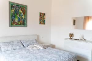 1 dormitorio con 1 cama y una pintura en la pared en Grazioso appartamento a due passi dal mare, en Minturno