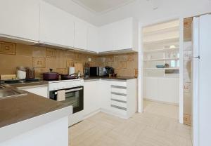 a kitchen with white appliances and wooden cabinets at Filis Sunny 80sqm apt in Viktoria in Athens