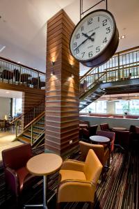 une horloge sur un poteau dans un restaurant avec des tables et des chaises dans l'établissement Royal National Hotel, à Londres