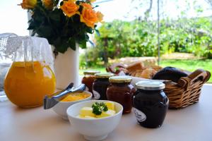 a table topped with jars of honey and a basket of food at Aan-Den-Weg in Stellenbosch