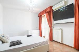 a bedroom with a bed and a flat screen tv at SUITE con 2 Balconi - 6 Guest in Prato
