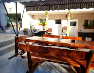 a wooden table and chairs on a patio at Casa Turta Dulce in Buşteni