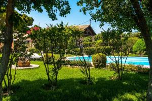 une cour avec une piscine et des arbres dans l'établissement Villa Loukia, à Spartià
