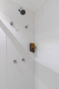 a bathroom with a shower with white tiles at My Home Studio - GRU in Guarulhos