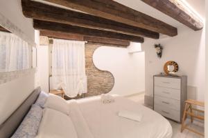 ein Schlafzimmer mit einem weißen Sofa und einer Ziegelwand in der Unterkunft La Vida by Venicevillas in Venedig