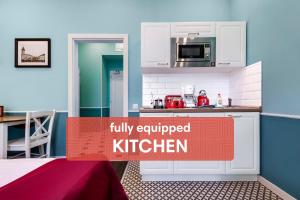 a kitchen with white cabinets and a sign that reads fully equipped kitchen at Revelton Studios Prague in Prague