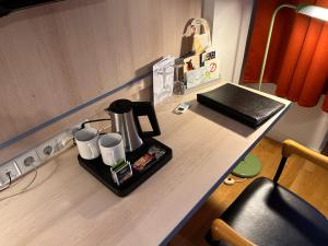a kitchen counter with a coffee maker and cups on it at Hotel Hansablick in Berlin