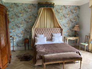 a bedroom with a large bed with a canopy at Castel Bois Marie, Maison d'hôtes in Montauban